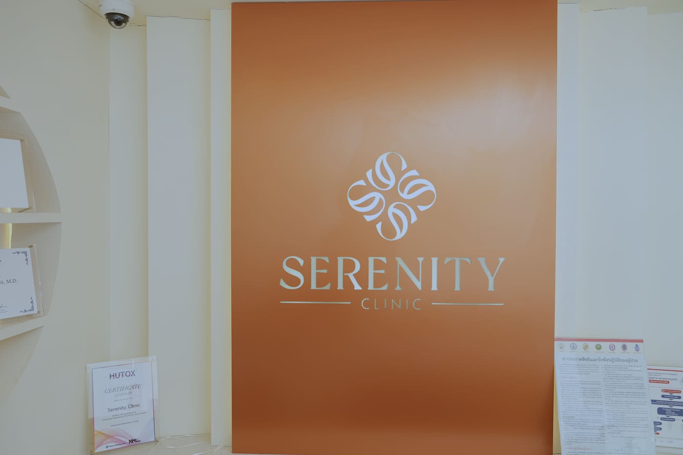 ผนังสีดินเผาพร้อมโลโก้ SERENITY CLINIC ในโถงต้อนรับ